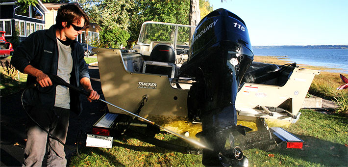 A man powerwashes of his boat to prevent spread of invasives. Photo provided by Quebec Ministry of Sustainable Development, Environment, Wildlife and Parks.